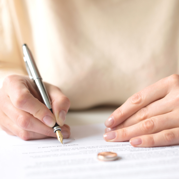 Close-up of woman's decision to sign divorce paperwork and protect assets